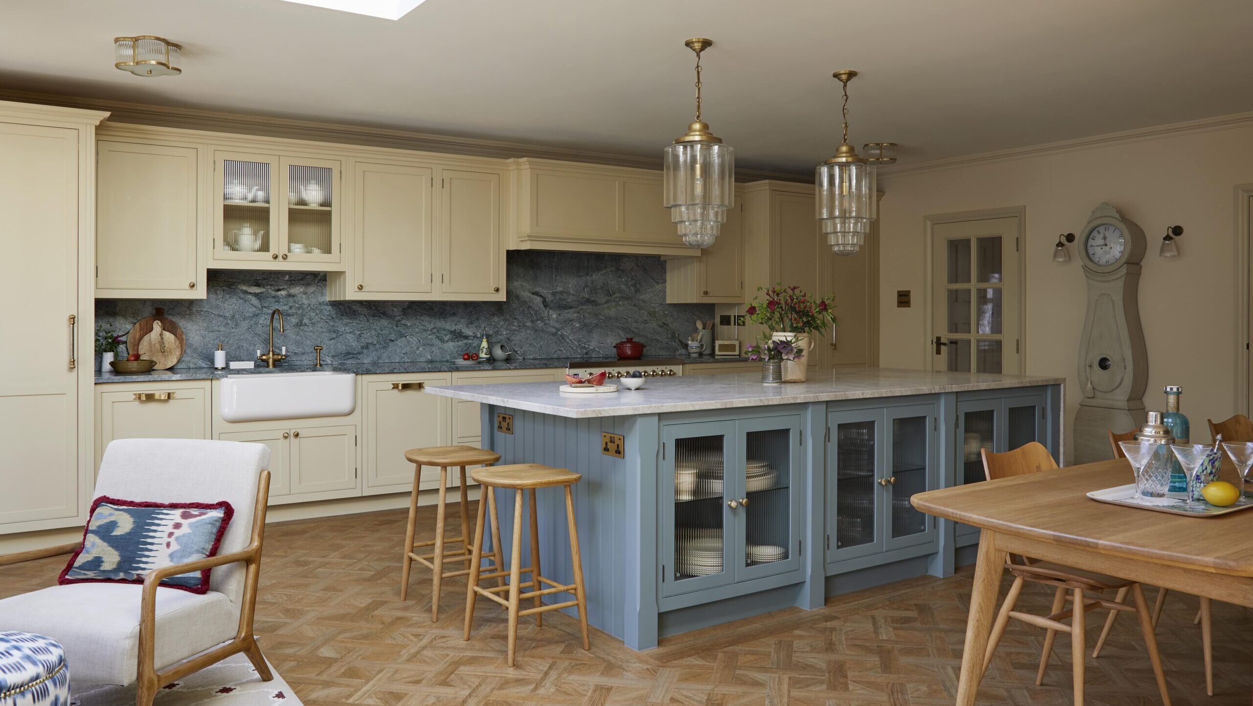 Light yellow and blue bespoke open plan kitchen with island and dining table