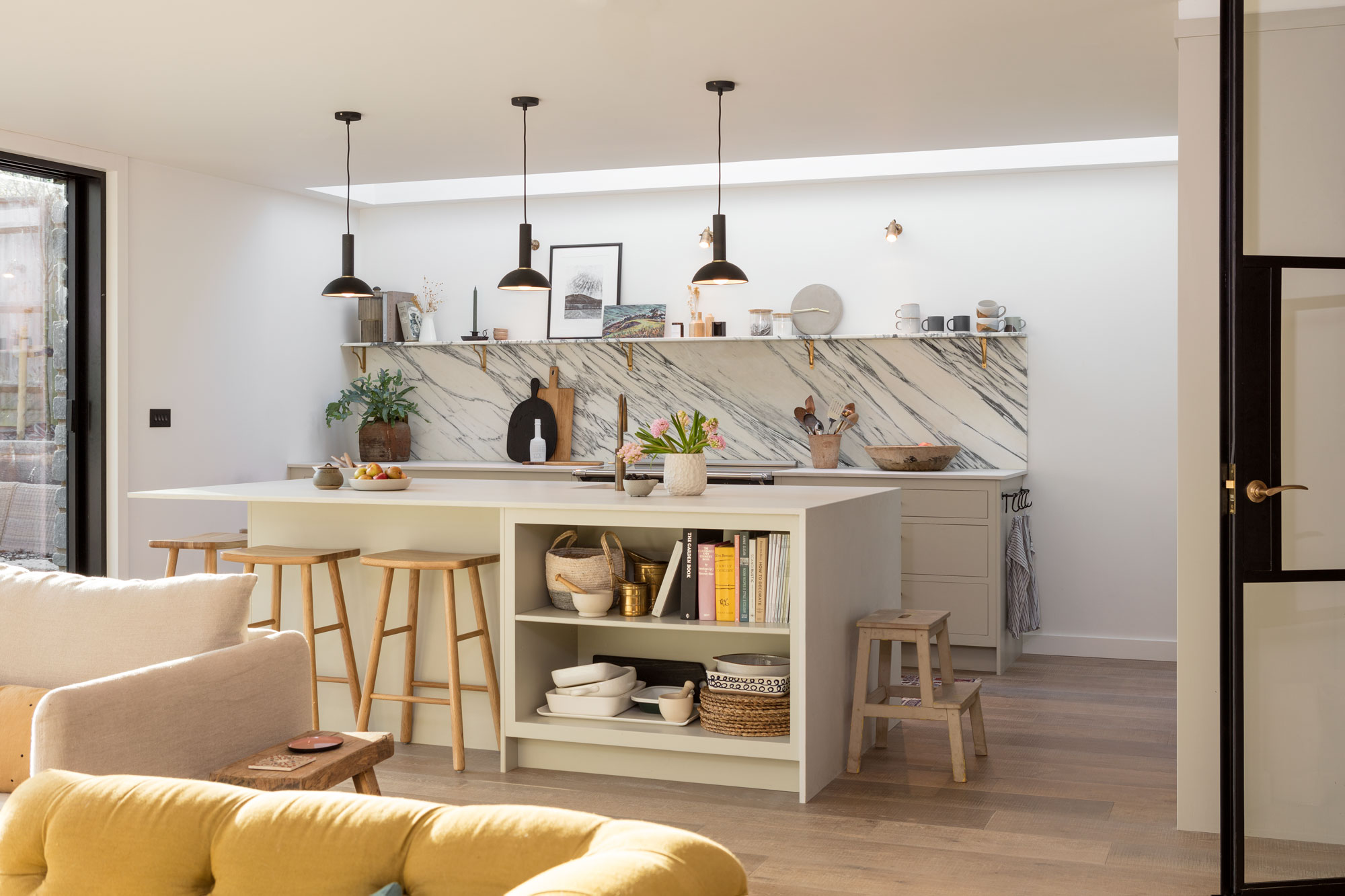 Neutral open plan kitchen diner with island and marble splashback