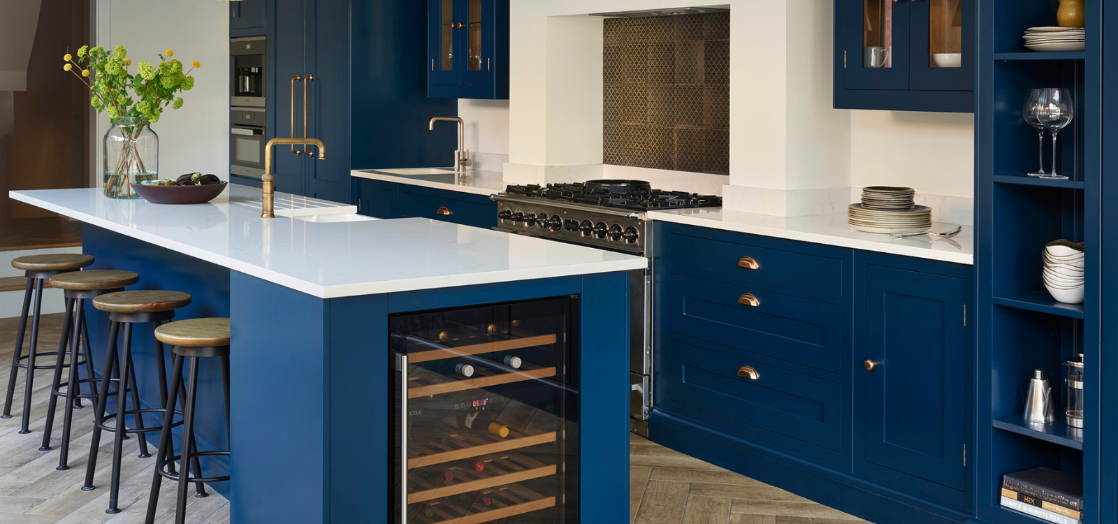 Navy blue kitchen with island seating and contrasting countertops with luxury kitchen appliances