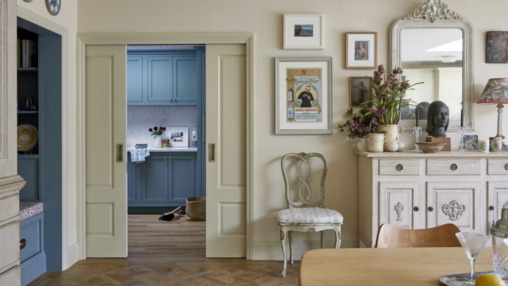 Bespoke utility room with pocket doors, blue cabinetry and countertop space
