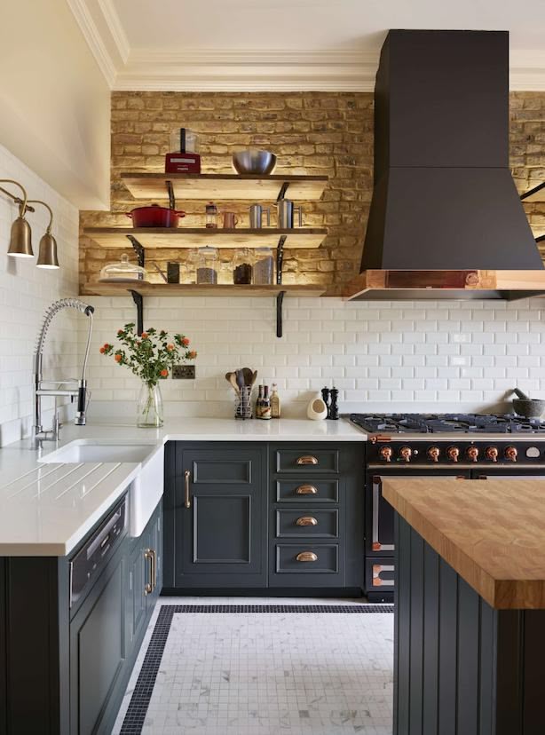 Dark green kitchen with industrial aesthetic featuring exposed brick wall with open shelving lighting