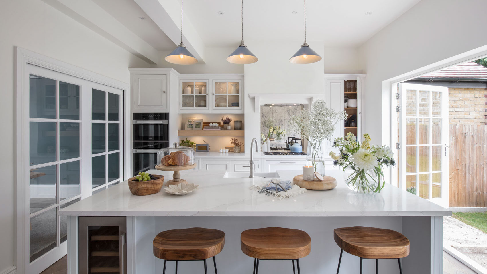 Neutral kitchen design with island wine fridge, island seating and pendant lighting and under cabinet lighting