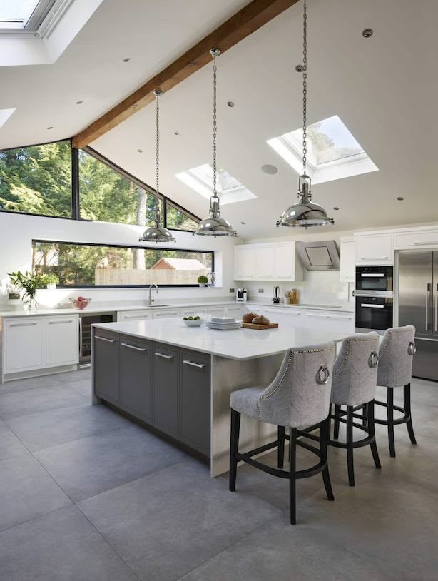 Open plan industrial kitchen with island and grey design, featuring natural light and statement features