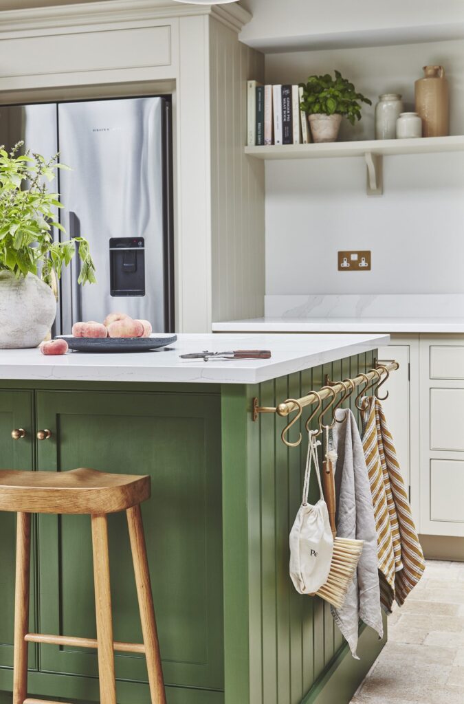 Green kitchen island in a cottage kitchen with natural light and open shelving