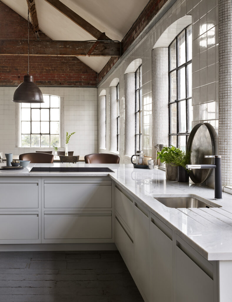 Contemporary handleless kitchen design with neutral cabinetry and L shaped layout