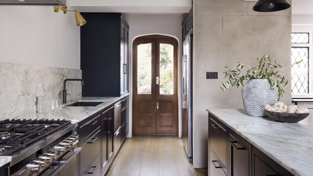 Navy blue period home kitchen with marble countertops and range cooker