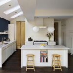 Low level kitchen design with white cabinetry and blue feature wall