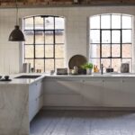 Industrial style kitchen with cream Linear Edge kitchen cabinetry and marble worktop