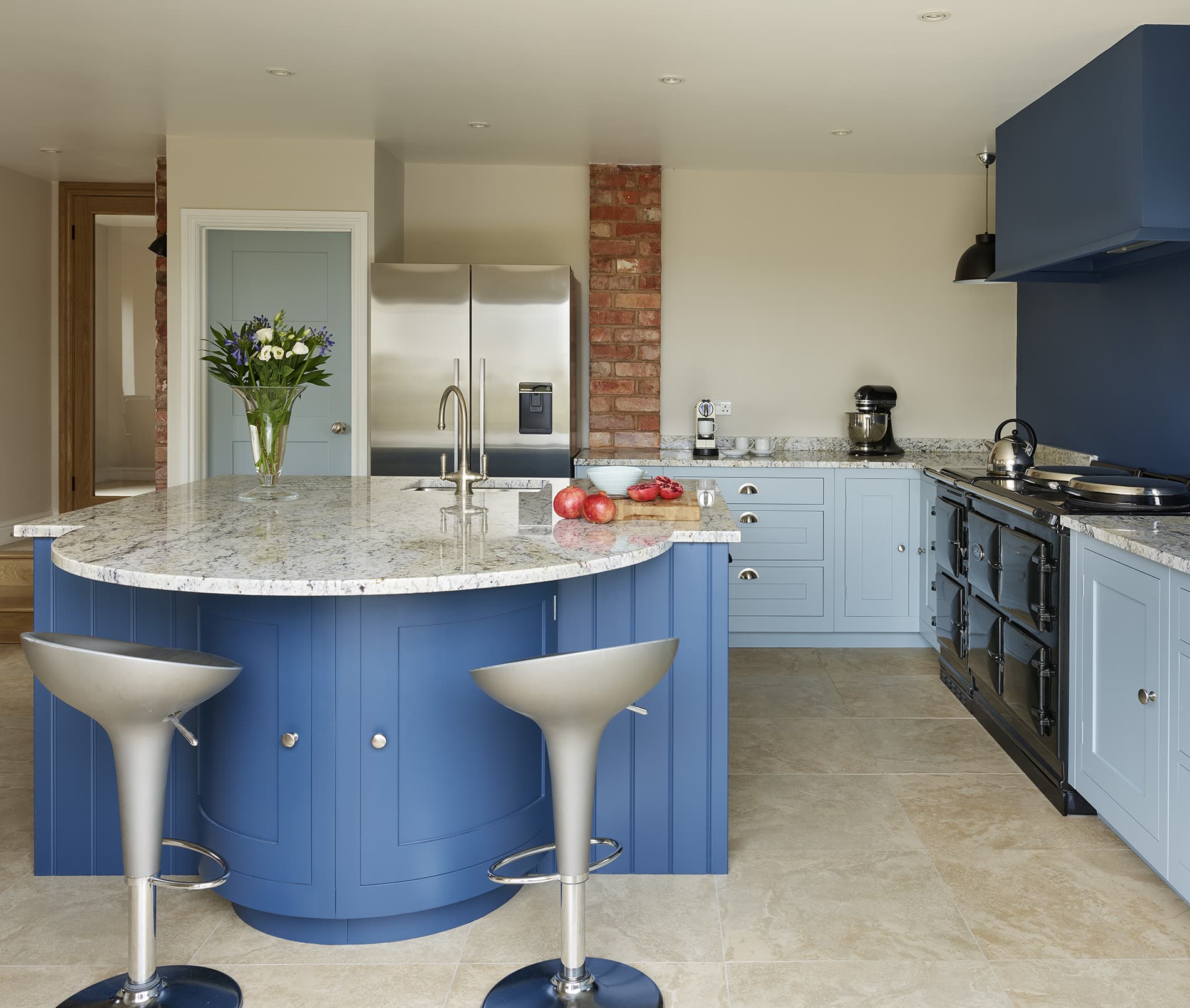 Blue curved kitchen island with granite worktop