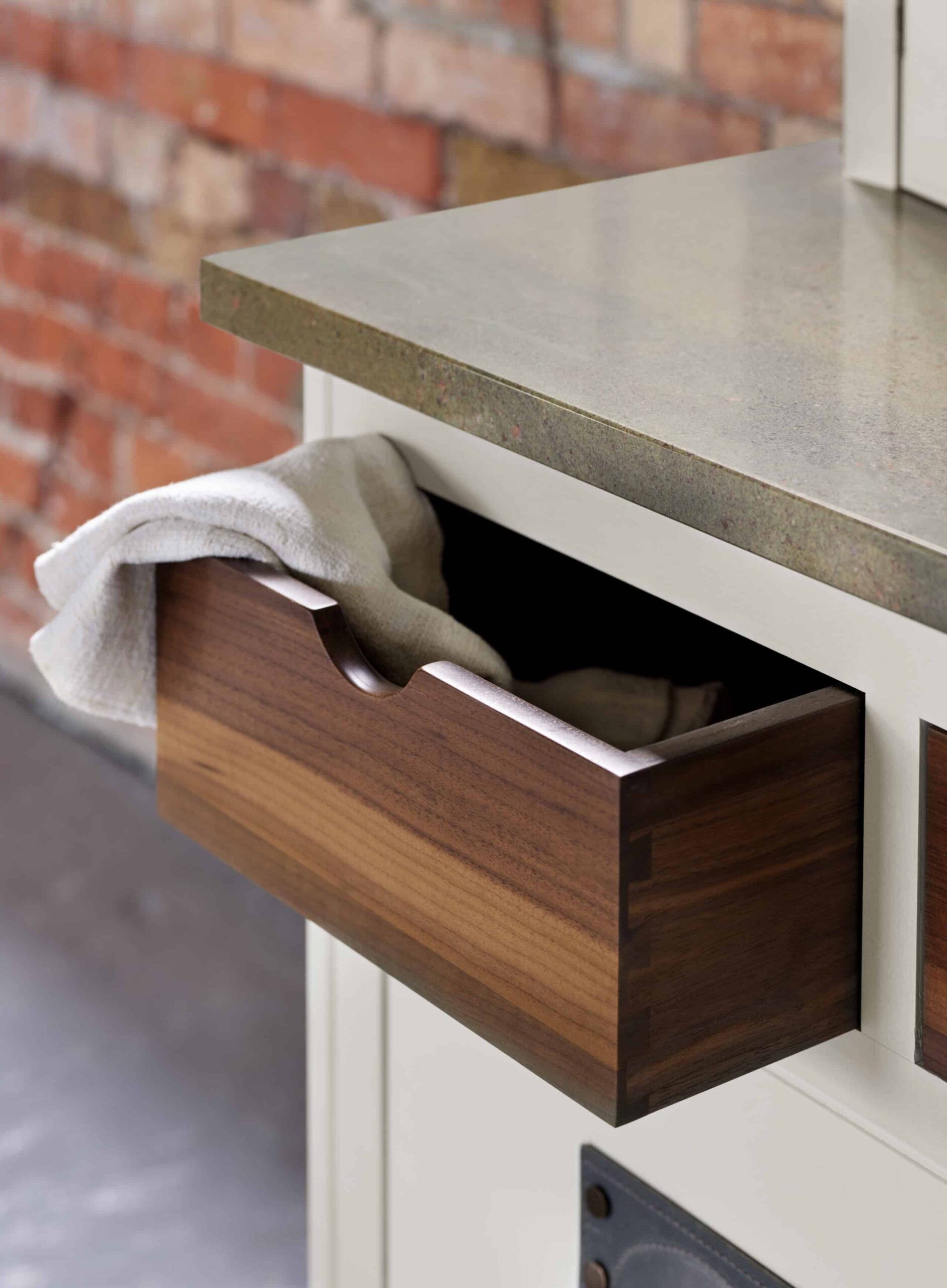 Walnut kitchen drawer with walnut interior open to show organised storage