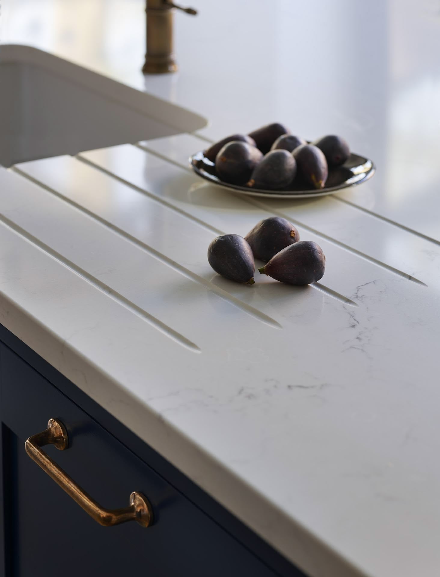 Closeup of white marble kitchen worktop with drainer grooves