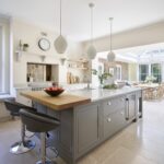 Grey kitchen island and white cabinetry featuring grey marble worktops