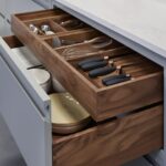 Grey kitchen drawer with walnut interior open to show organised cutlery storage