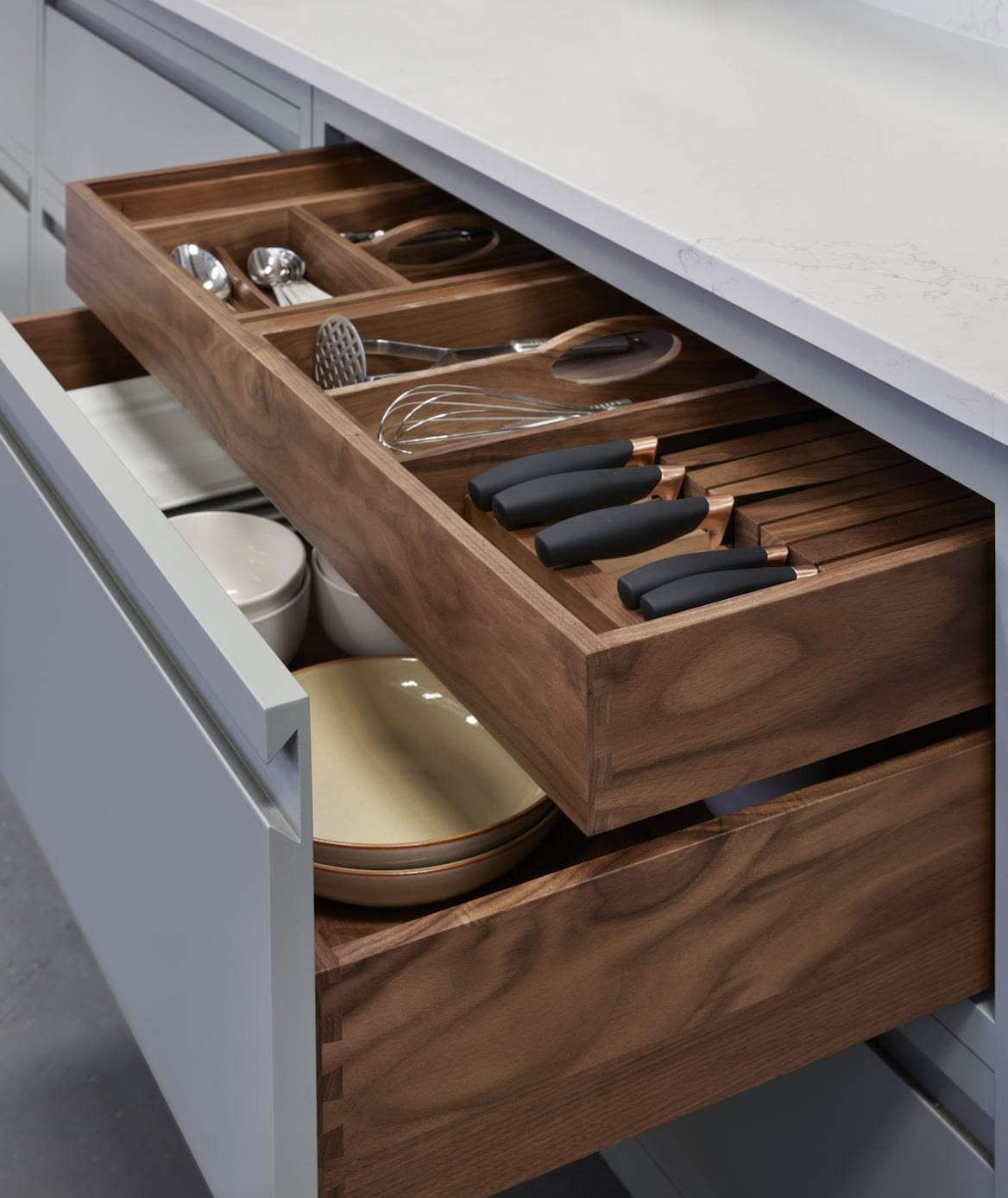 Grey kitchen drawer with walnut interior open to show organised cutlery storage