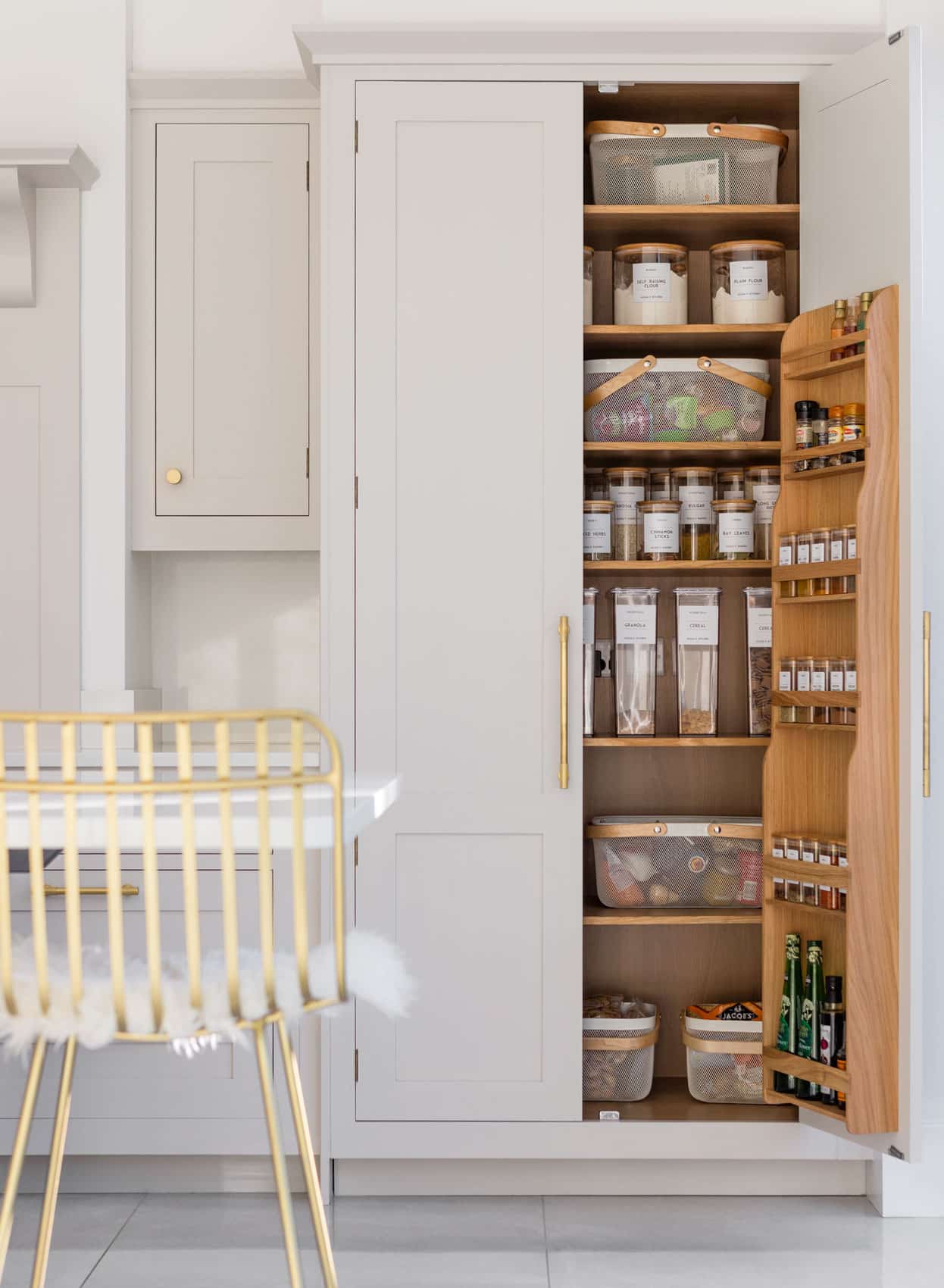 White tall pantry with double doors open to show organised storage