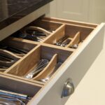 Grey kitchen drawer with oak interior open to show organised cutlery storage