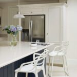 Blue kitchen island with white worktop and white stools