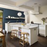 Low level white kitchen island with natural wood stools
