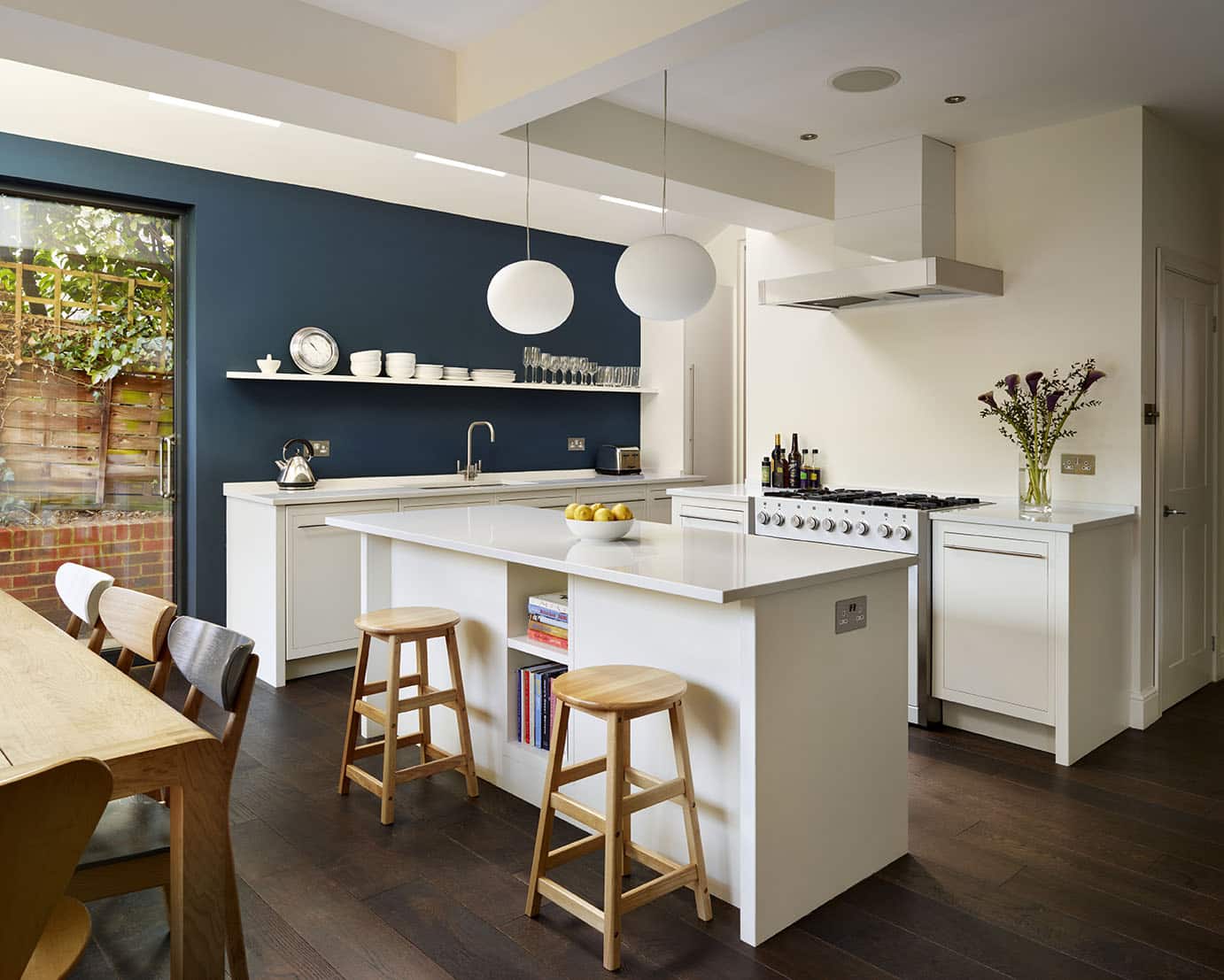 Low level white kitchen island with natural wood stools