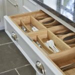Grey kitchen drawer with oak interior open to show organised cutlery storage