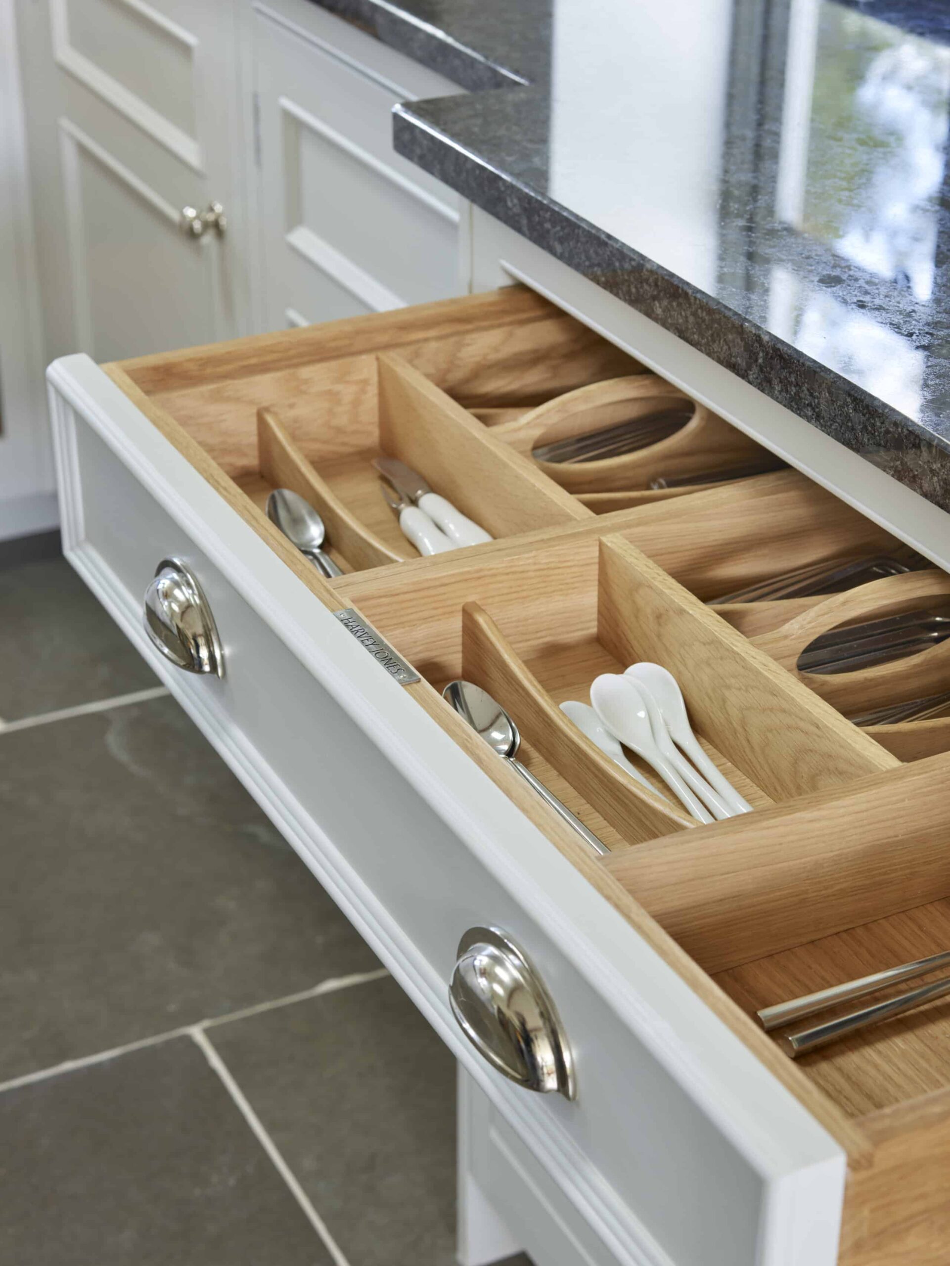 Grey kitchen drawer with oak interior open to show organised cutlery storage