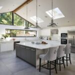 Grey kitchen island with white worktop and grey chairs