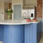 Blue curved kitchen island with granite worktop
