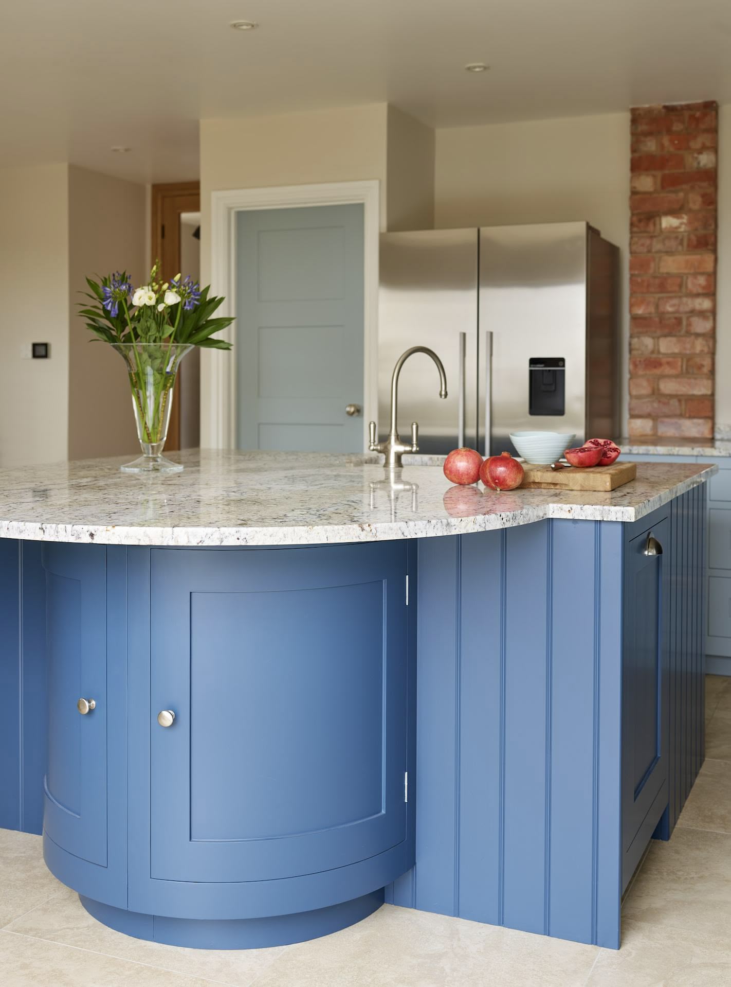 Blue curved kitchen island with granite worktop