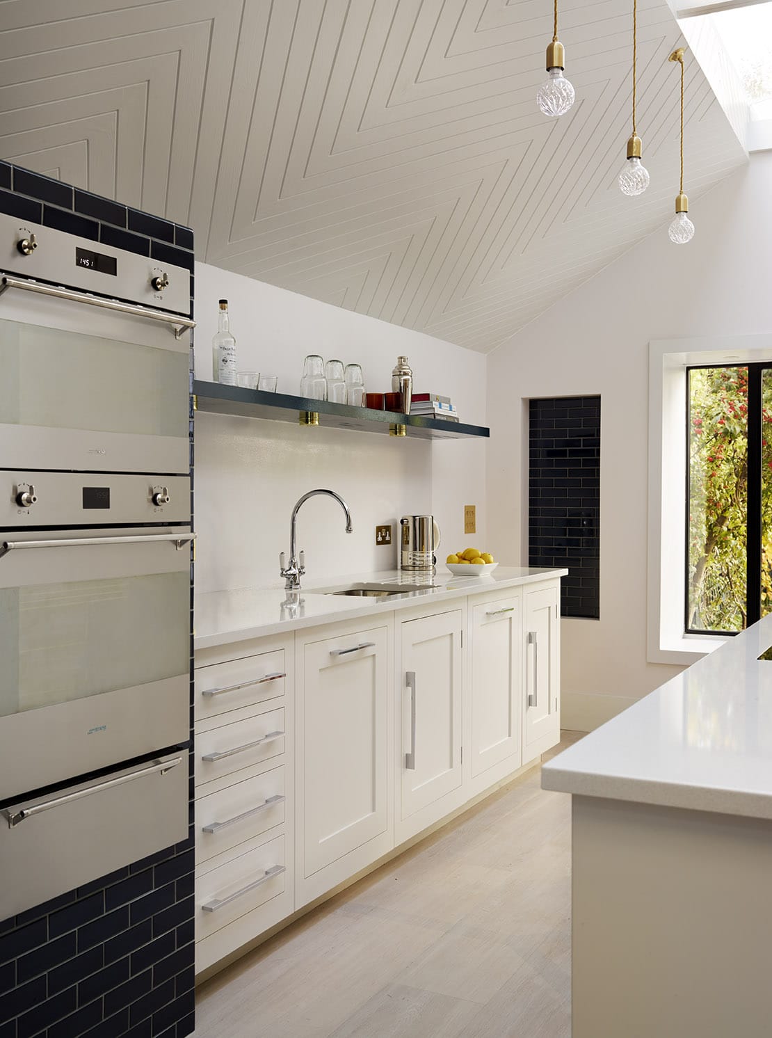 Modern bright white Shaker kitchen with integrated appliances