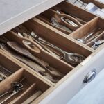 Closeup of a white Arbor kitchen draw with wooden cutlery dividers