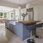 Grey kitchen island and white cabinetry featuring grey marble worktops