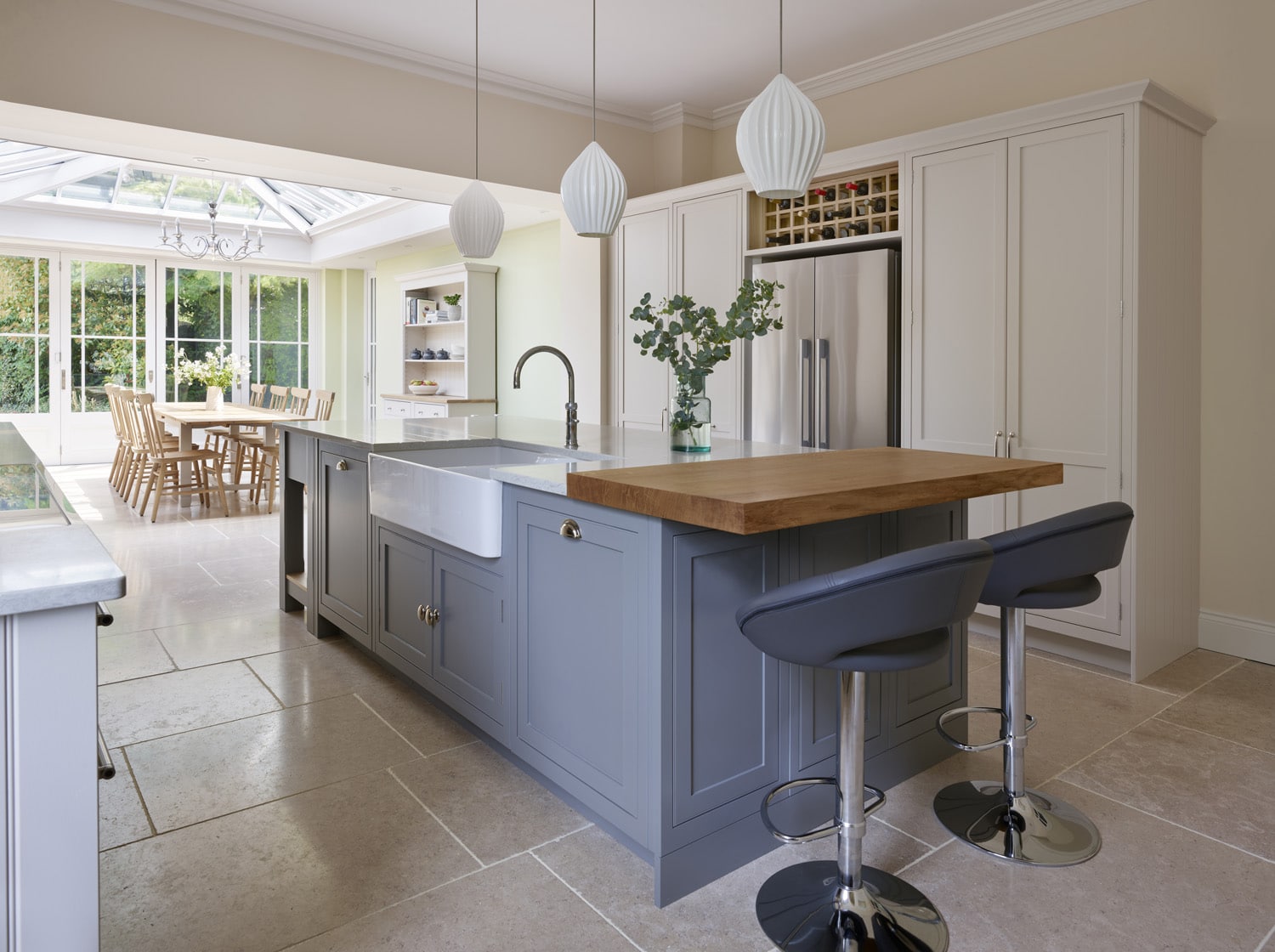 Grey kitchen island and white cabinetry featuring grey marble worktops