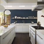 Low level kitchen design with white cabinetry and blue feature wall