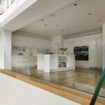 White Linear family kitchen viewed from stairs below