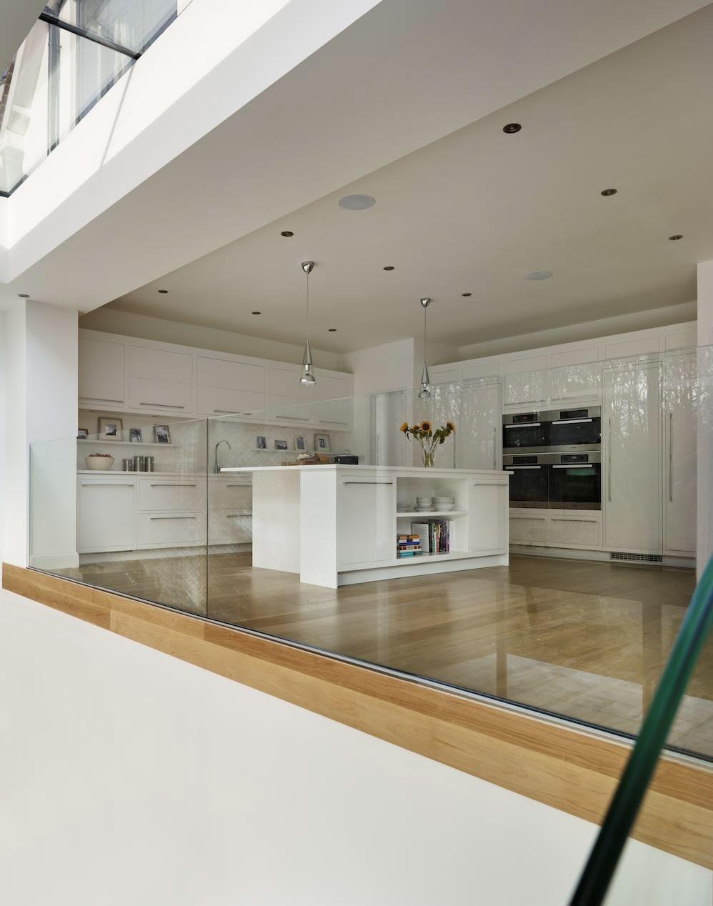 White Linear family kitchen viewed from stairs below