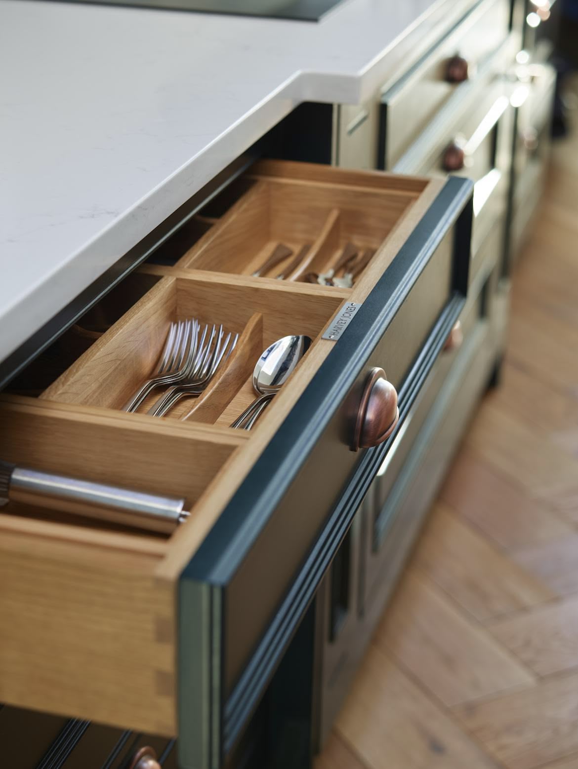 Green kitchen drawer with oak interior open to show organised cutlery storage