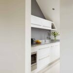 White Linear kitchen cabinetry viewed from kitchen entrance