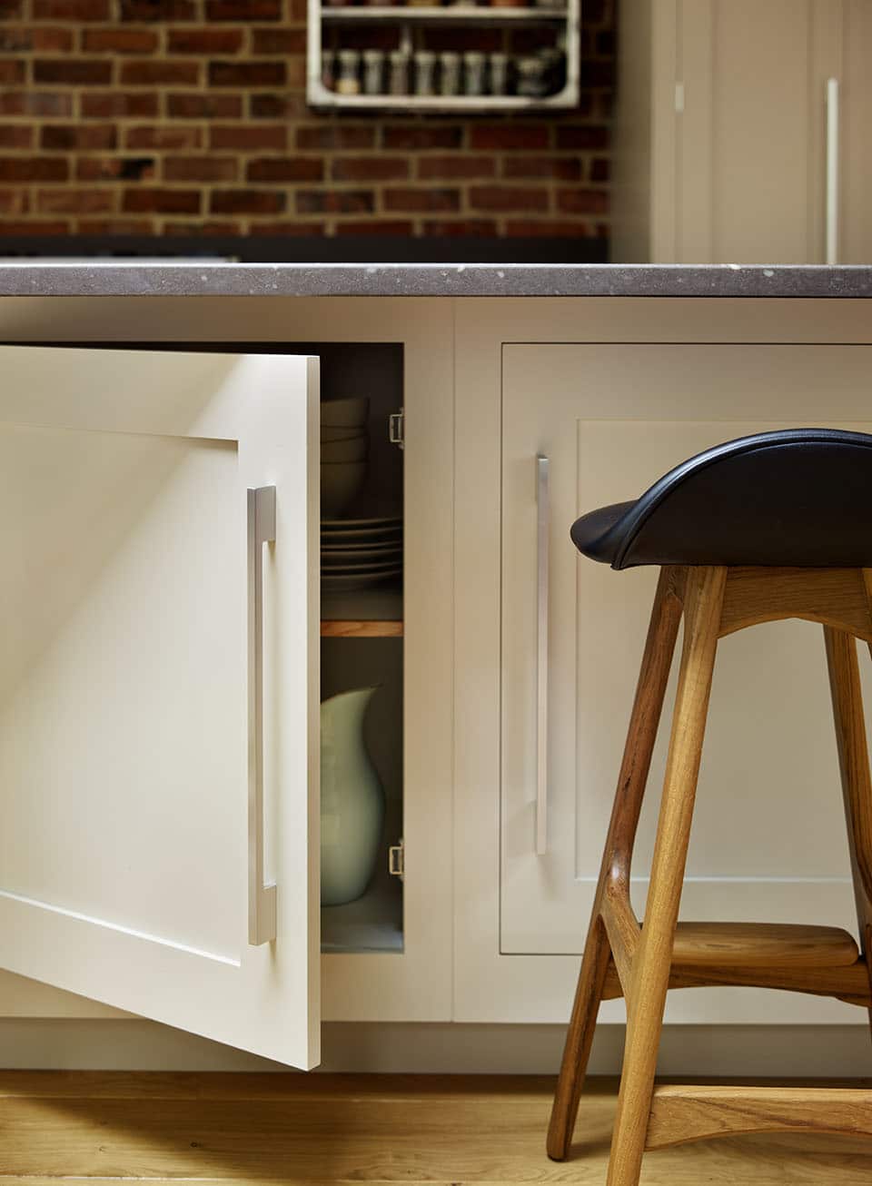 White Shaker kitchen island cupboard open to reveal organised storage
