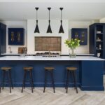 Navy Shaker kitchen island with white worktop and black and brown bar stools