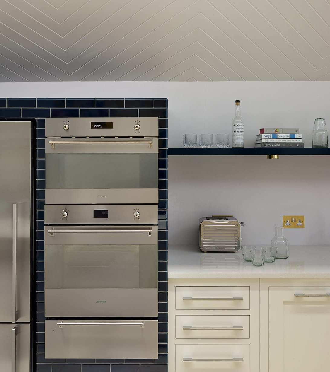 Blue tiled kitchen unit framing cooking appliances
