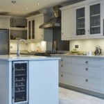 White Arbor kitchen design featuring white cabinetry and kitchen island with wooden stool