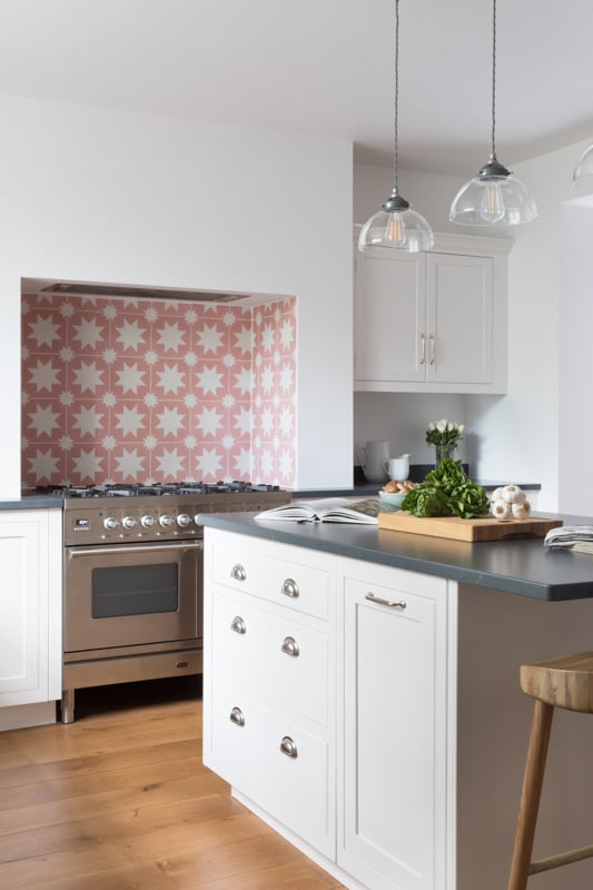 White Arbor kitchen design featuring pink and white decorative tiling around the cooker area