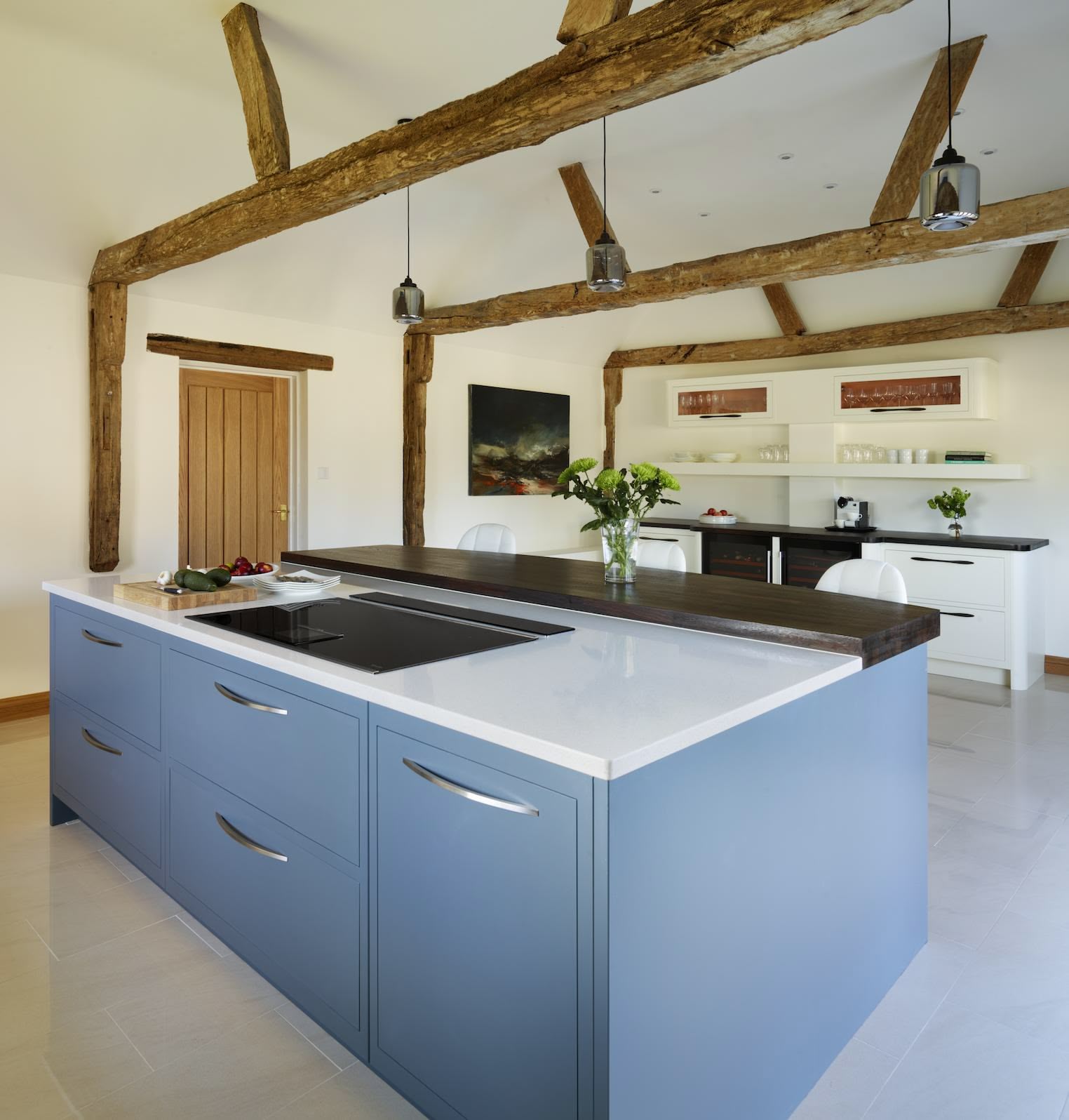 Blue kitchen island with silver handles, white worktop and black extension