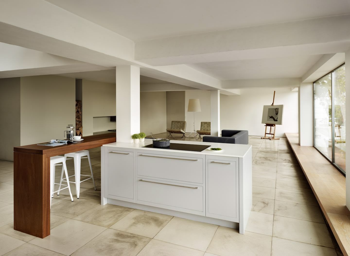Open plan white Linear kitchen with walnut breakfast bar looking onto living area