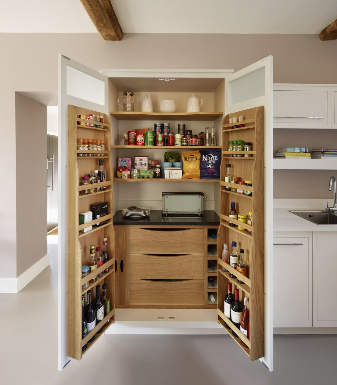 White parge pantry with open doors to reveal natural wooden interior and organised storage with drawers
