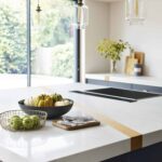 White kitchen island worktop with gold band detail and integrated hob