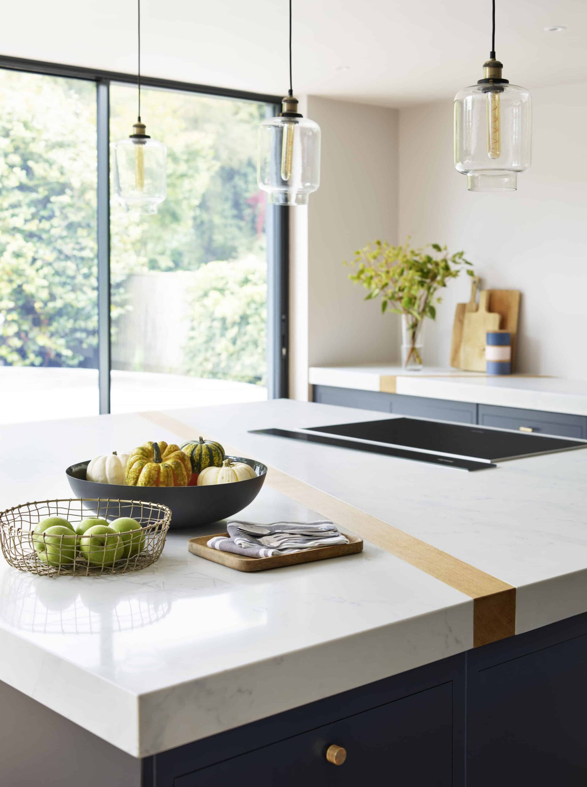 White kitchen island worktop with gold band detail and integrated hob