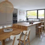 Open plan kitchen dining area and linear edge kitchen design in natural colours