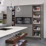 Grey tall pantry next to kitchen oven and cabinetry, open to show organised storage