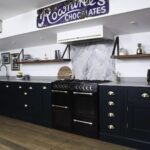 Rich green Shaker kitchen cabinetry and grey worktops
